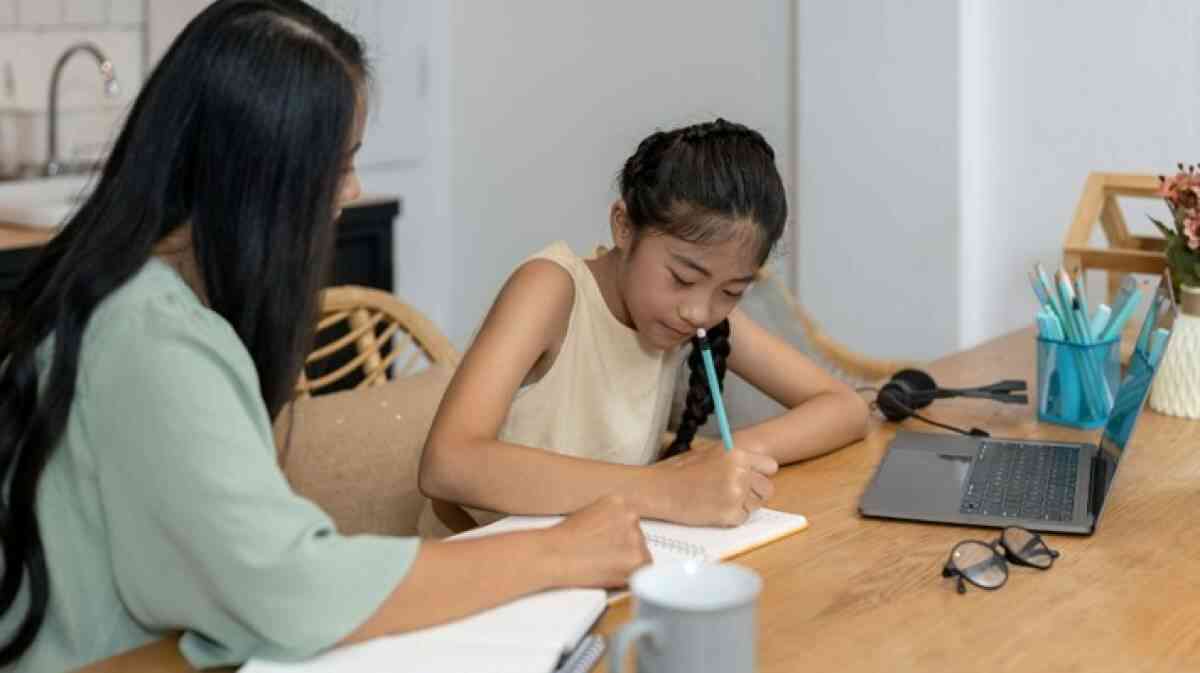 Mother providing English tuition to her young daughter.