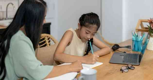 Mother providing English tuition to her young daughter.